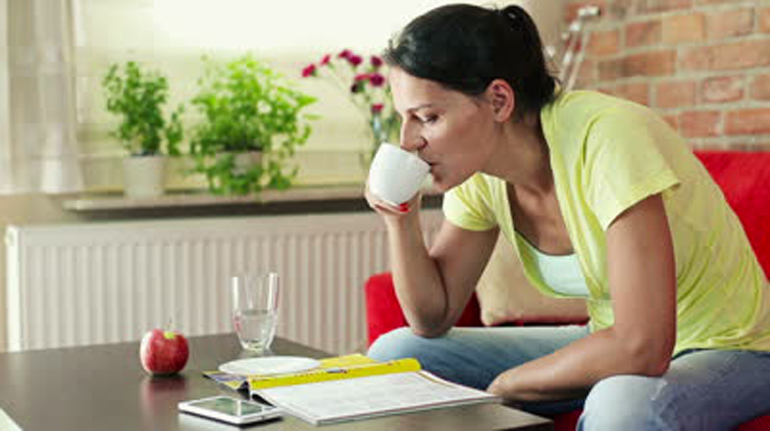 stock-footage-young-woman-reading-magazine-and-drinking-coffee