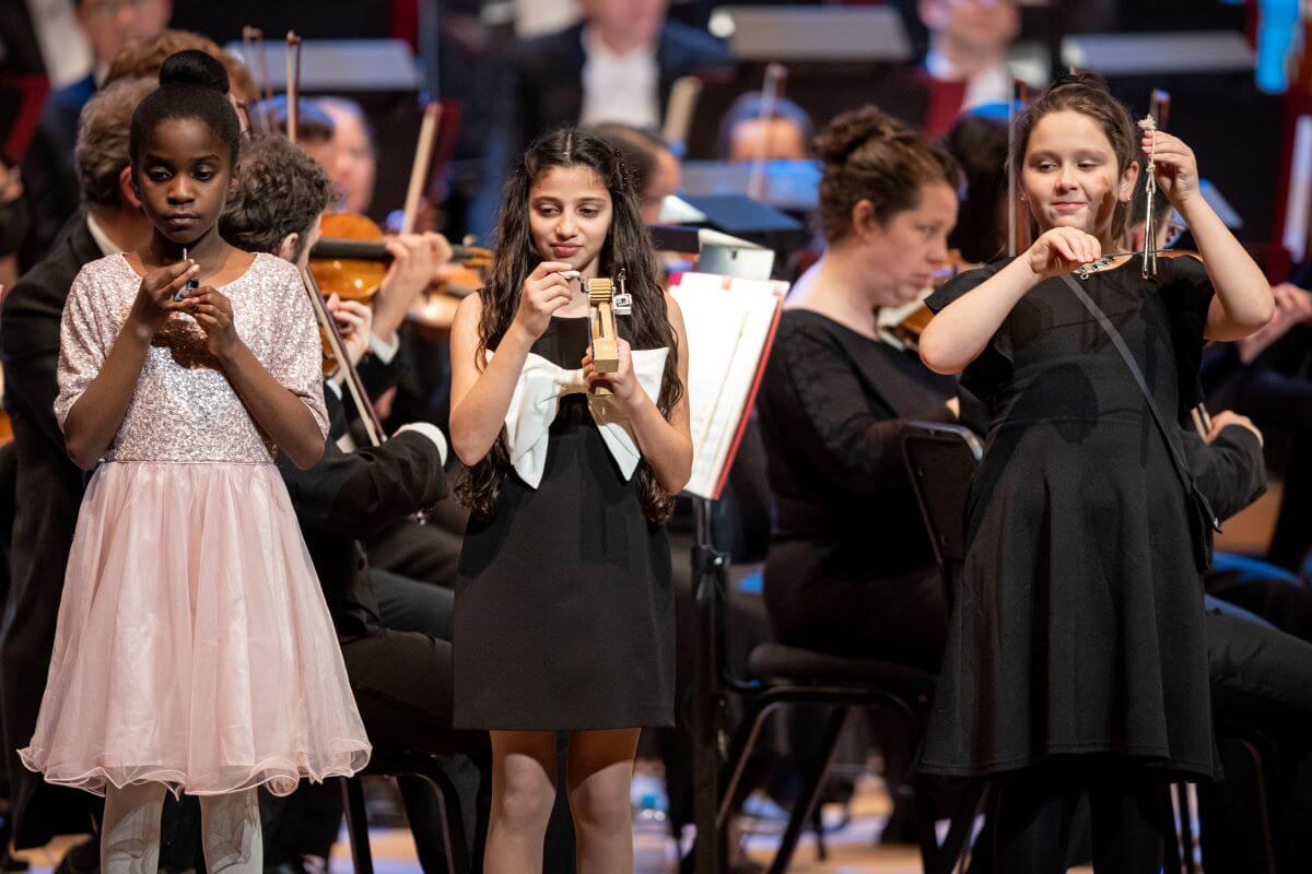 Trois jeunes participantes du programme La musique aux enfants au concert "Chantons Noël avec Rafael Payare" du 14 décembre 2022. (Photo: Antoine Saito)