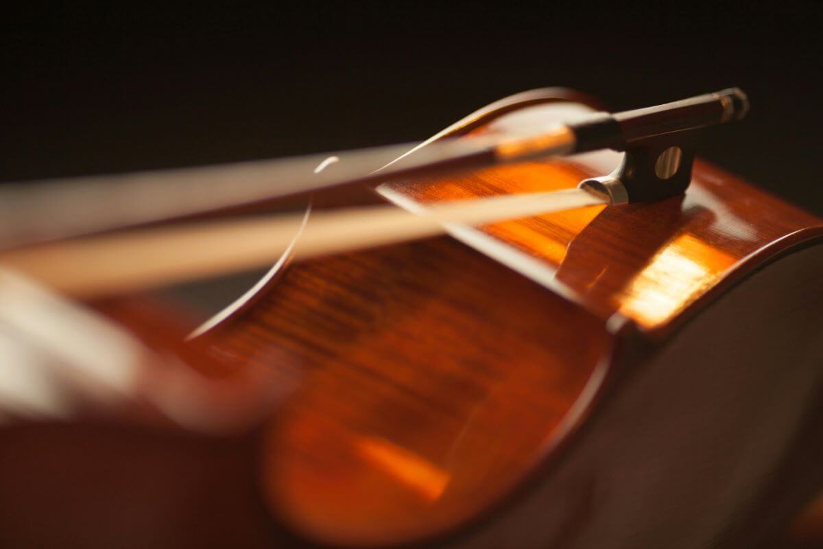 Un violoncelle couché sur le côté avec un archet déposé dessus. (Photo : Méline Waxx)