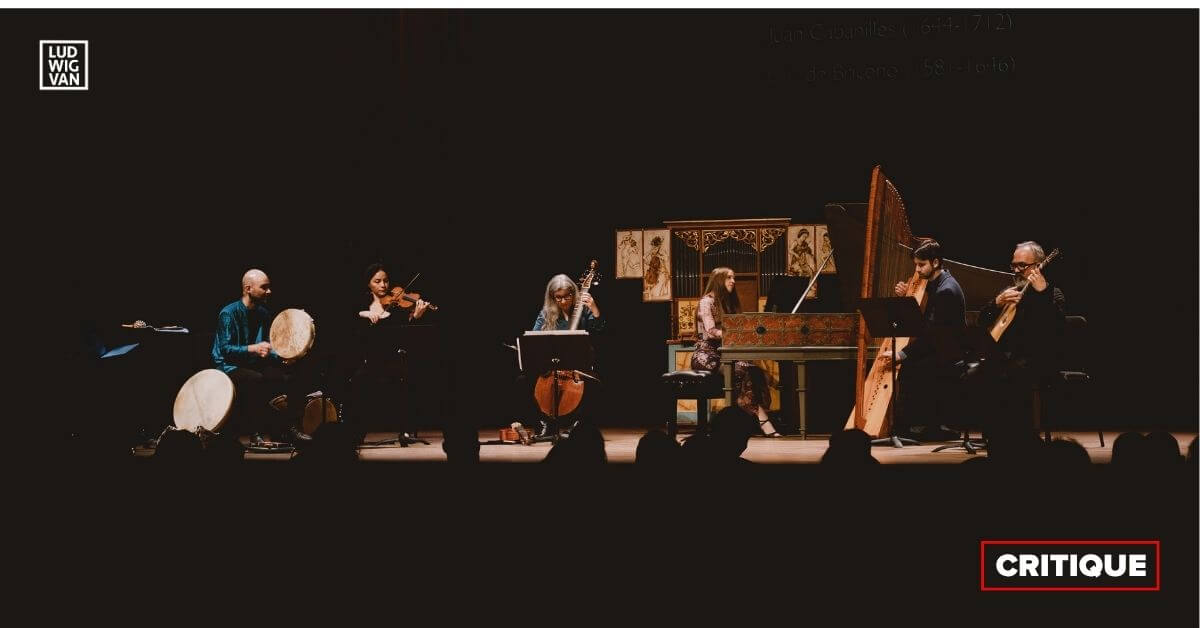 Assis en ligne sur scène à la Salle Bourgie le 6 mai dernier, les instrumentistes du groupe Les Idées heureuses, spécialisé en musique ancienne et baroque, se détachent dans des tons chauds contre un fond noir. (Photo : Brandon Patitucci)