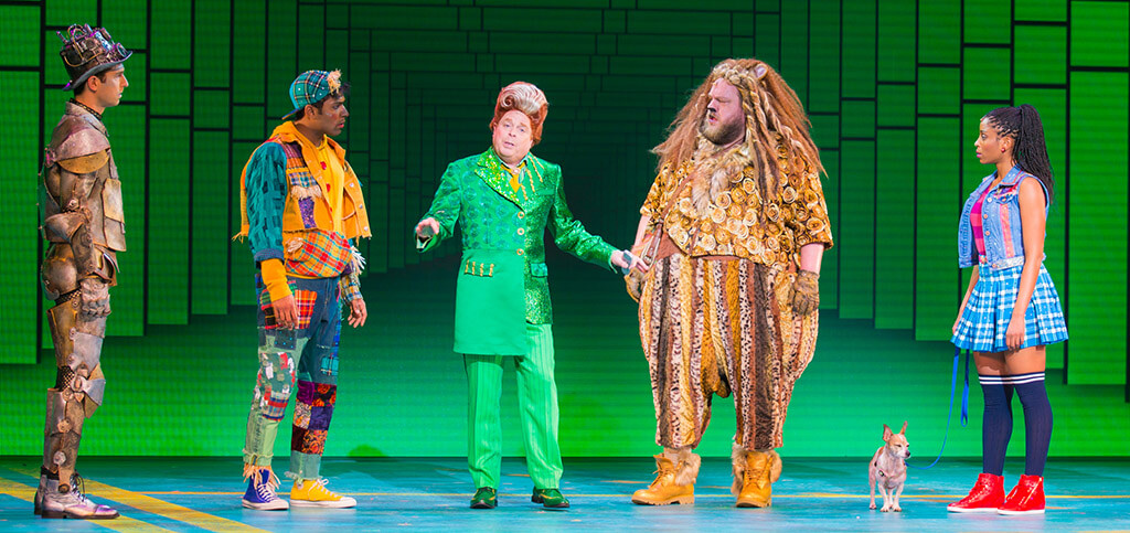 Eric Craig as Tin Man, Matt Nethersole as Scarecrow, Eddie Glen as Mr. Green, Daniel Williston as Lion, Olive as Toto, Camille Eanga-Selenge as Dorothy. (Photo: Racheal McCaig)