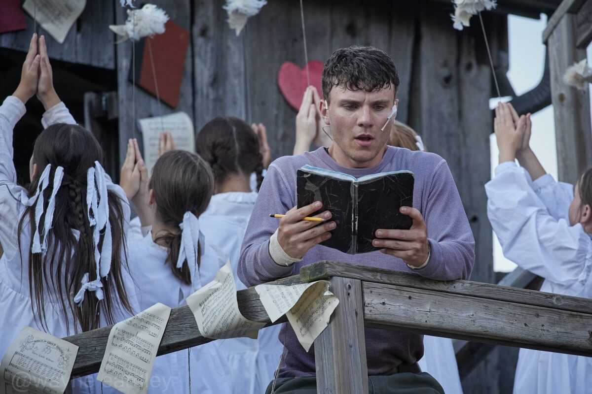 Alexei DeLuca as Ewart Rokosh and company in 4th Line Theatre’s production of Schoolhouse by Leanna Brodie, directed and choreographed by Monica Dottor, costumes by Chelsea Day, set design by Michelle Chesser (Photo: Wayne Eardley, Brookside Studio)